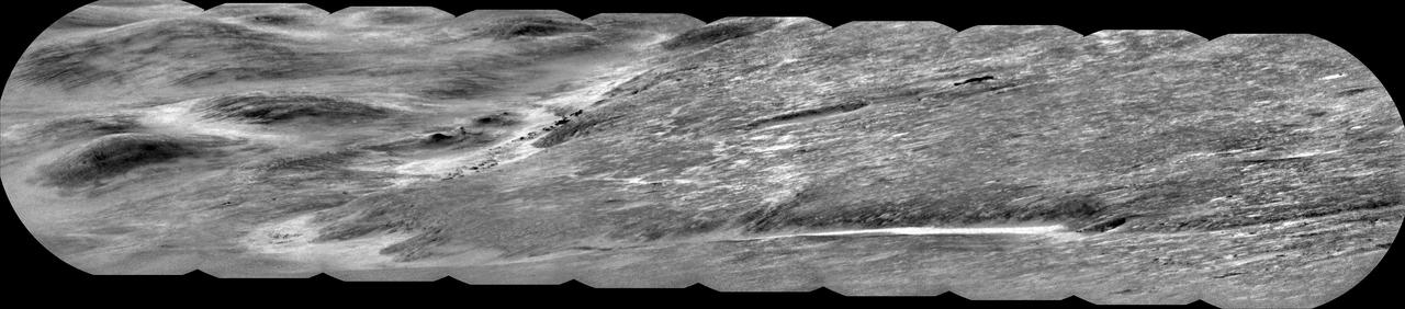 NASA's Curiosity Mars rover used its ChemCam instrument to capture Peace Vallis, an ancient river channel descending Gale Crater's rim, on Sept. 1, 2025 (the 4,647th Martian day, or sol, of the mission). The channel was about 19 miles (30 kilometers) from Curiosity as it explores the foothills of Mount Sharp, a 3-mile-tall (5-kilometer-tall) mountain.  The dark features scattered just left of center within the channel are rocky outcrops. While Curiosity has taken pictures of Peace Vallis in the past, this is the first time details like these have been seen within it. Water and sediment are believed to have flowed down Peace Vallis into Gale Crater billions of years ago, creating a fan of sediment across the crater floor. Studying the crater's watery past is part of Curiosity's overall mission to understand where and how well the ancient Martian landscape could have supported microbial life, if any ever formed there.  ChemCam is equipped with the Remote Micro Imager, or RMI, a black-and-white camera that can be used like a small telescope to see distant features, creating a circular "spyglass" image. Ten RMI images were stitched together on Earth into a mosaic to create the panorama seen here.  https://photojournal.jpl.nasa.gov/catalog/PIA26637