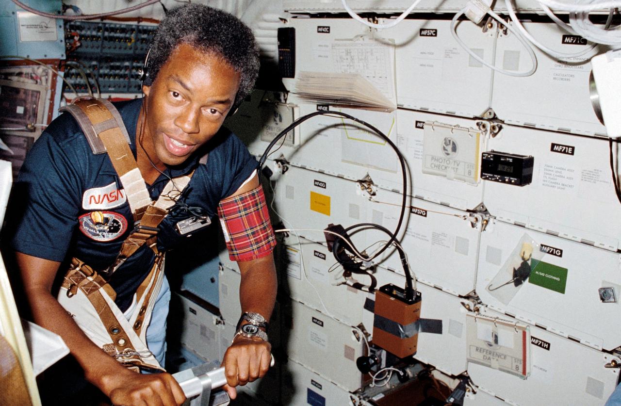 STS008-13-0361 (30 Aug.-5 Sept. 1983) --- Astronaut Guion S. Bluford, STS-8 mission specialist, assists Dr. William E. Thornton (out of frame) with a medical test that requires use of the treadmill exercising device designed for spaceflight by the STS-8 medical doctor. This frame was shot with a 35mm camera. Photo credit: NASA