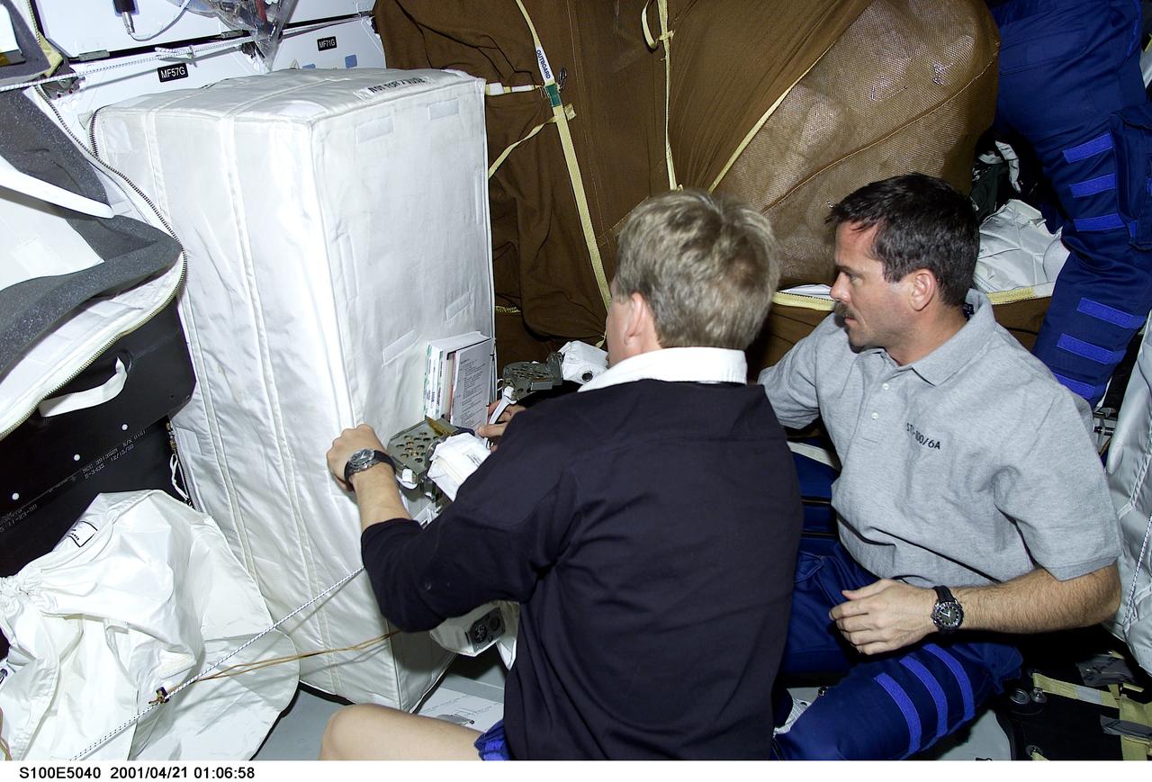 S100-E-5040 (21 April 2001) --- Astronauts Scott E. Parazynski (left) and Chris A. Hadfield of the Canadian Space Agency, both mission specialists, are seen on the middeck of the Space Shuttle Endeavour as the STS-100 crew anticipates its union with the International Space Station (ISS). Assigned space-walking astronauts Hadfield and Parazynski were later joined on the middeck by spacewalk coordinator John L. Phillips in conducting some final checks of the suits and hardware that are to be used during the next day's planned 6-hour, 30-minute spacewalk. The image was recorded with a digital still camera.
