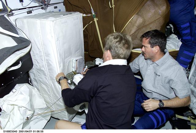 NASA image: MS Parazynski and MS Hadfield look through a stowage bag on the middeck of Endeavour