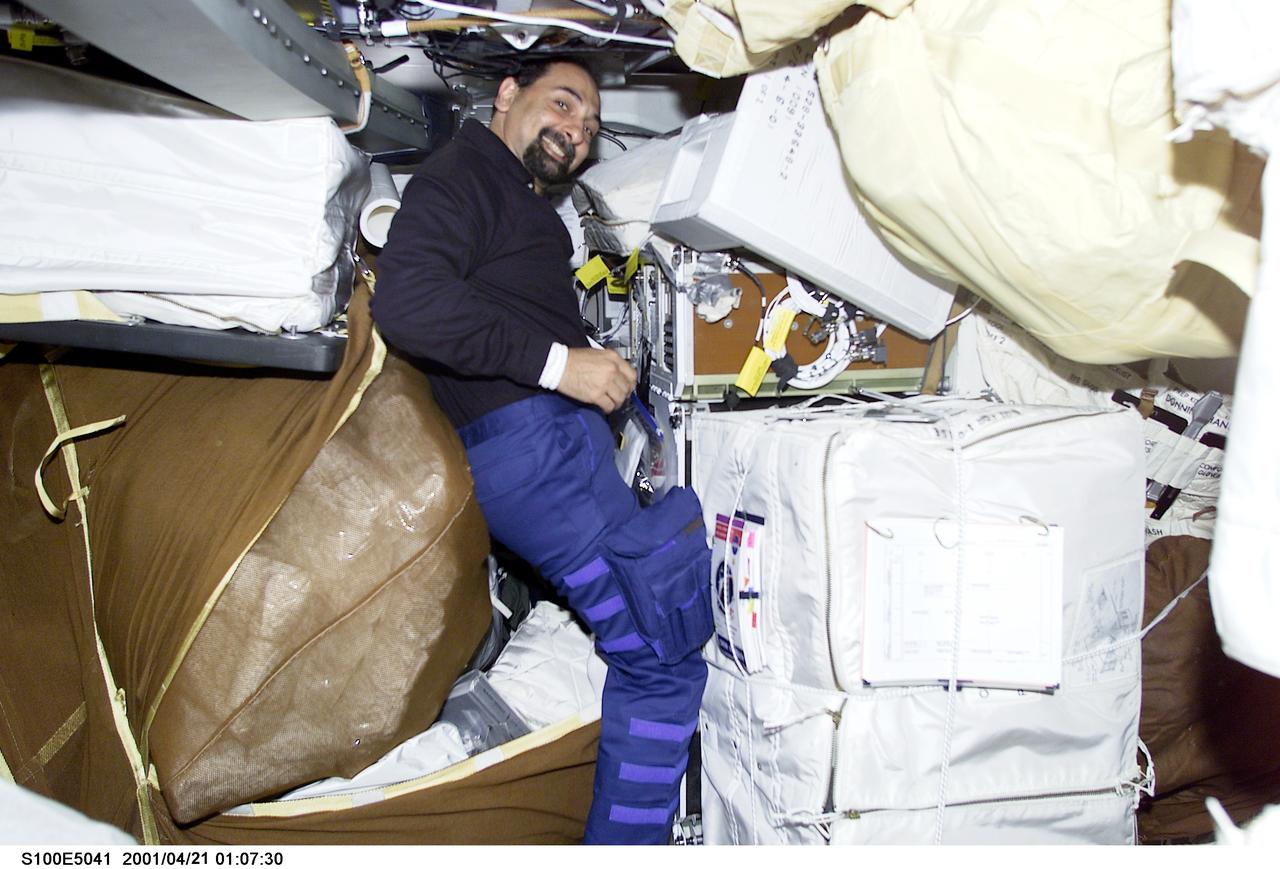 S100-E-5041 (21 April 2001) --- Astronaut Umberto Guidoni, STS-100 mission specialist representing the European Space Agency, checks equipment and supplies on the middeck of the Space Shuttle Endeavour as the crew anticipates its union with the International Space Station (ISS).  The image was recorded with a digital still camera.