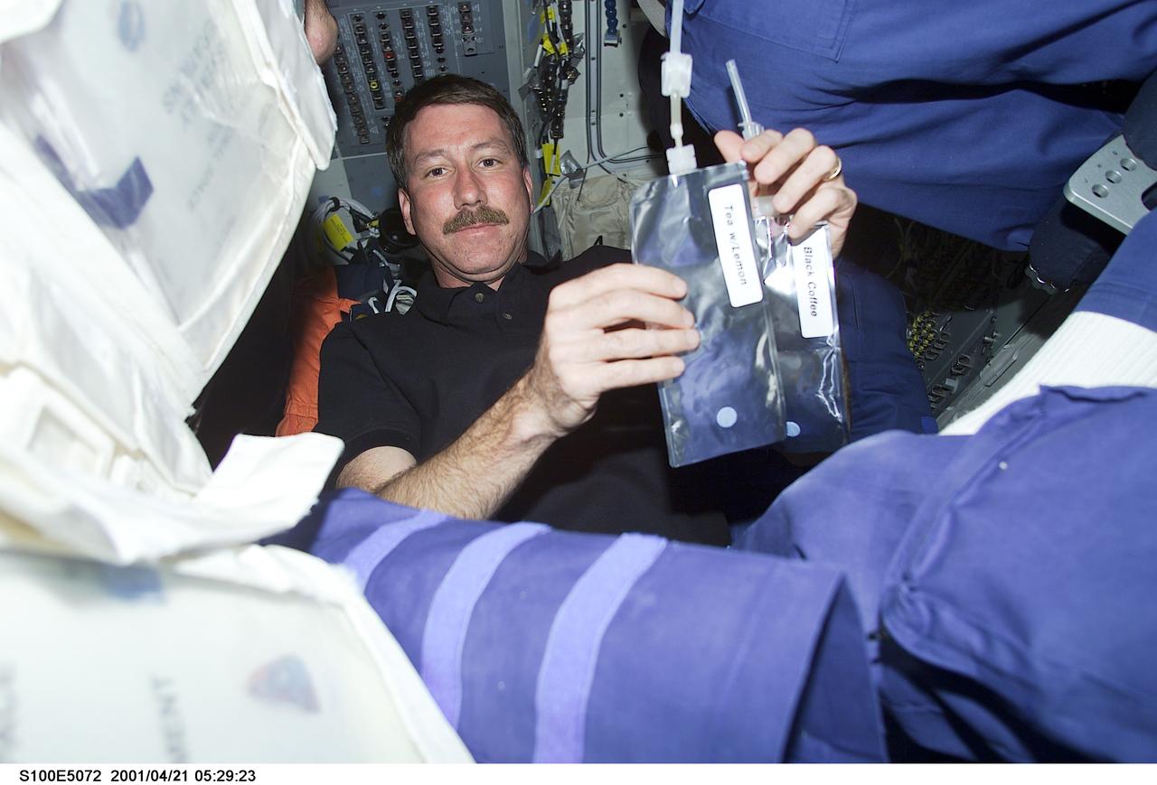 S100-E-5072 (21 April 2001) --- Astronaut Kent V. Rominger, mission commander for STS-100, is pictured on the middeck of the Space Shuttle Endeavour as the shuttle steadily makes its way toward the International Space Station (ISS) following an April 19 launch. Rominger is taking a brief pause from a very heavy work agenda that'll only get busier once the shuttle and the orbiting outpost have docked. The mission commander is obviously trying to decide between black coffee (right) or tea with lemon. This image was recorded by a fellow crew member using a digital still camera.