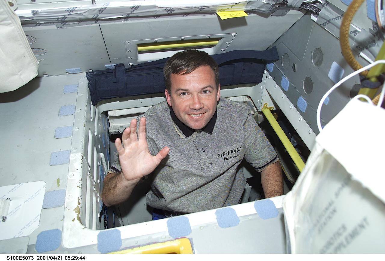 S100-E-5073 (21 April 2001) --- Cosmonaut Yuri V. Lonchakov, mission specialist representing Rosaviakosmos, waves to a crew mate while translating through the passageway between the middeck and flight deck onboard the Earth-orbiting Space Shuttle Endeavour. The image was recorded with a digital still camera.