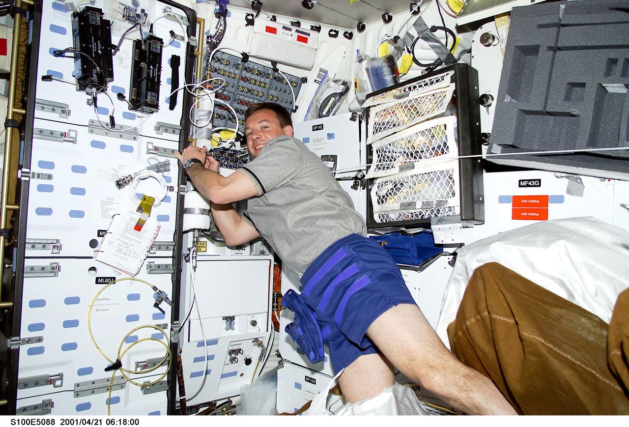 S100-E-5088 (21 April 2001) --- Cosmonaut Yuri V. Lonchakov, STS-100 mission specialist representing Rosaviakosmos, is pictured with temporarily-stowed equipment and supplies onboard the Space Shuttle Endeavour as the spacecraft heads toward a rendezvous with the International Space Station (ISS). The middeck scene was recorded with a digital still camera.