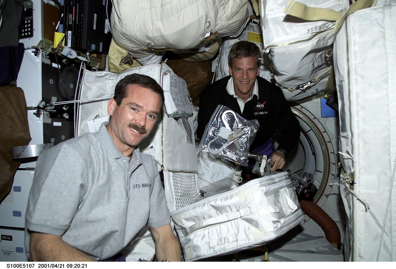 S100-E-5107 (21 April 2001) --- Astronauts Chris A. Hadfield (left) of the Canadian Space Agency and Scott E. Parazynski, both mission specialists, are seen on the middeck of the Space Shuttle Endeavour as the STS-100 crew anticipates its union with the International Space Station (ISS). Assigned space-walking astronauts Hadfield and Parazynski were later joined on the middeck by spacewalk coordinator John L. Phillips in conducting some final checks of the suits and hardware that are to be used during the next day's planned 6-hour, 30-minute spacewalk. The image was recorded with a digital still camera.