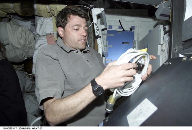 Pilot Ashby unpacks a cable on the middeck of Endeavour