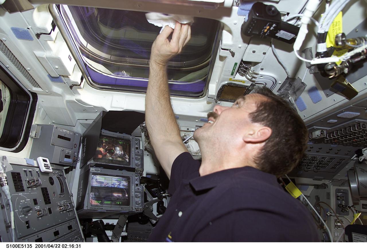 S100-E-5135 (21 April 2001) --- Astronaut Chris A. Hadfield of the Canadian Space Agency (CSA) wipes clean one of the overhead windows on the aft flight deck of the Space Shuttle Endeavour as the seven-member STS-100 crew prepares for rendezvous with the orbital outpost. The photo was recorded with a digital still camera.