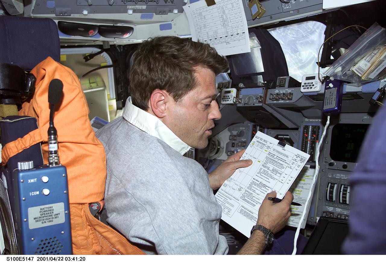 S100-E-5147 (21 April 2001) --- Astronaut Jeffrey S. Ashby, pilot, temporarily positioned at the commander's station on the forward flight deck of the Space Shuttle Endeavour, goes over a check list of  tasks and manuevers.  The image was recorded with a digital still camera.