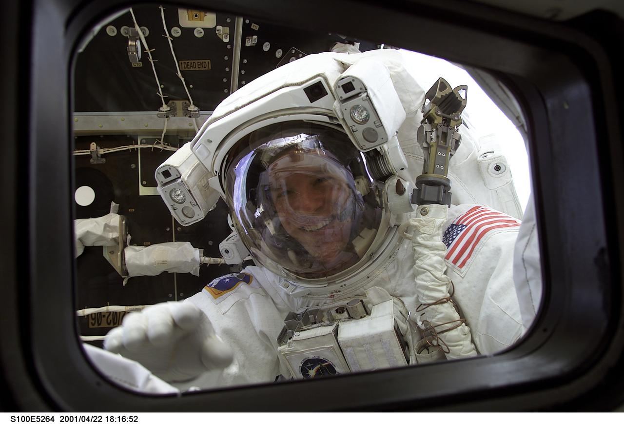 S100-E-5264 (22 April 2001) --- A smiling astronaut Scott E. Parazynski, STS-100 mission specialist, peers into the crew cabin of the Space Shuttle Endeavour during a lengthy spacewalk to perform important work on the International Space Station (ISS). The Pressurized Mating Adapter (PMA-2), which temporarily anchors the orbital outpost to the shuttle, can be seen behind the astronaut. The picture was recorded with a digital still camera.