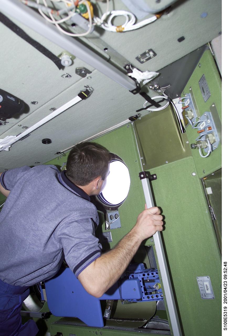 S100-E-5319 (23 April 2001) --- Cosmonaut Yuri V. Lonchakov, STS-100 mission specialist representing Rosaviakosmos, looks out a porthole in the Zvezda Service Module as he makes his first visit to the International Space Station (ISS). The picture was taken with a digital still camera.