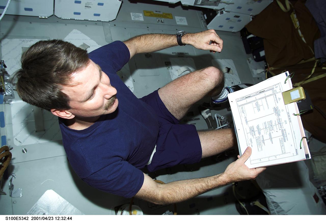 S100-E-5342 (23 April 2001) --- Astronaut Kent V. Rominger, STS-100 mission commander, economizes his time as he looks over flight data while working out on an ergometer device on the middeck of the Space Shuttle Endeavour. The scene was recorded with a digital still camera.