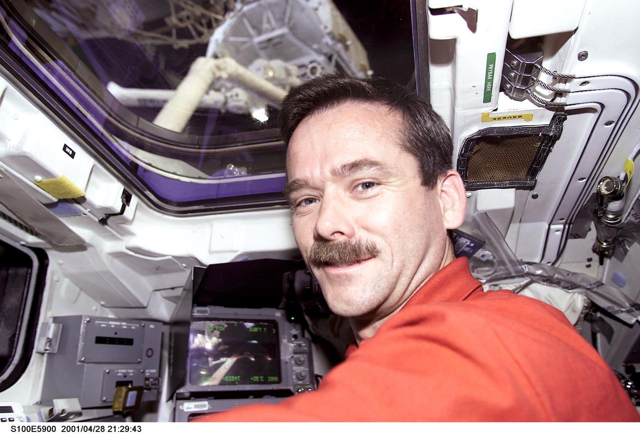 S100-E-5900 (28 April 2001) --- Astronaut Chris A. Hadfield, mission specialist, is pictured on the aft flight deck of the Space Shuttle Endeavour during an historic event. A Canadian “handshake in space” occurred at 4:02 p.m (CDT), April 28, 2001, as the Canadian-built space station robotic arm – operated by Expedition Two flight engineer Susan Helms – transferred its launch cradle over to Endeavour’s robotic arm, with Canadian Space Agency astronaut Hadfield at the controls. The exchange of the pallet from station arm to shuttle arm marked the first ever robotic-to-robotic transfer in space. This image was recorded with a digital still camera.