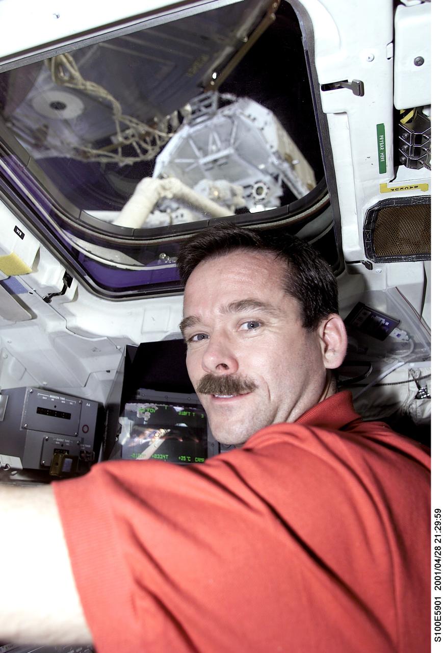 S100-E-5901 (28 April 2001) --- Astronaut Chris A. Hadfield, mission specialist, is pictured on the aft flight deck of the Space Shuttle Endeavour during an historic event. A Canadian “handshake in space” occurred at 4:02 p.m (CDT), April 28, 2001, as the Canadian-built space station robotic arm – operated by Expedition Two flight engineer Susan J. Helms – transferred its launch cradle over to Endeavour’s robotic arm, with Canadian Space Agency astronaut Hadfield at the controls. The exchange of the pallet from station arm to shuttle arm marked the first ever robot-to-robot transfer in space. This image was recorded with a digital still camera.