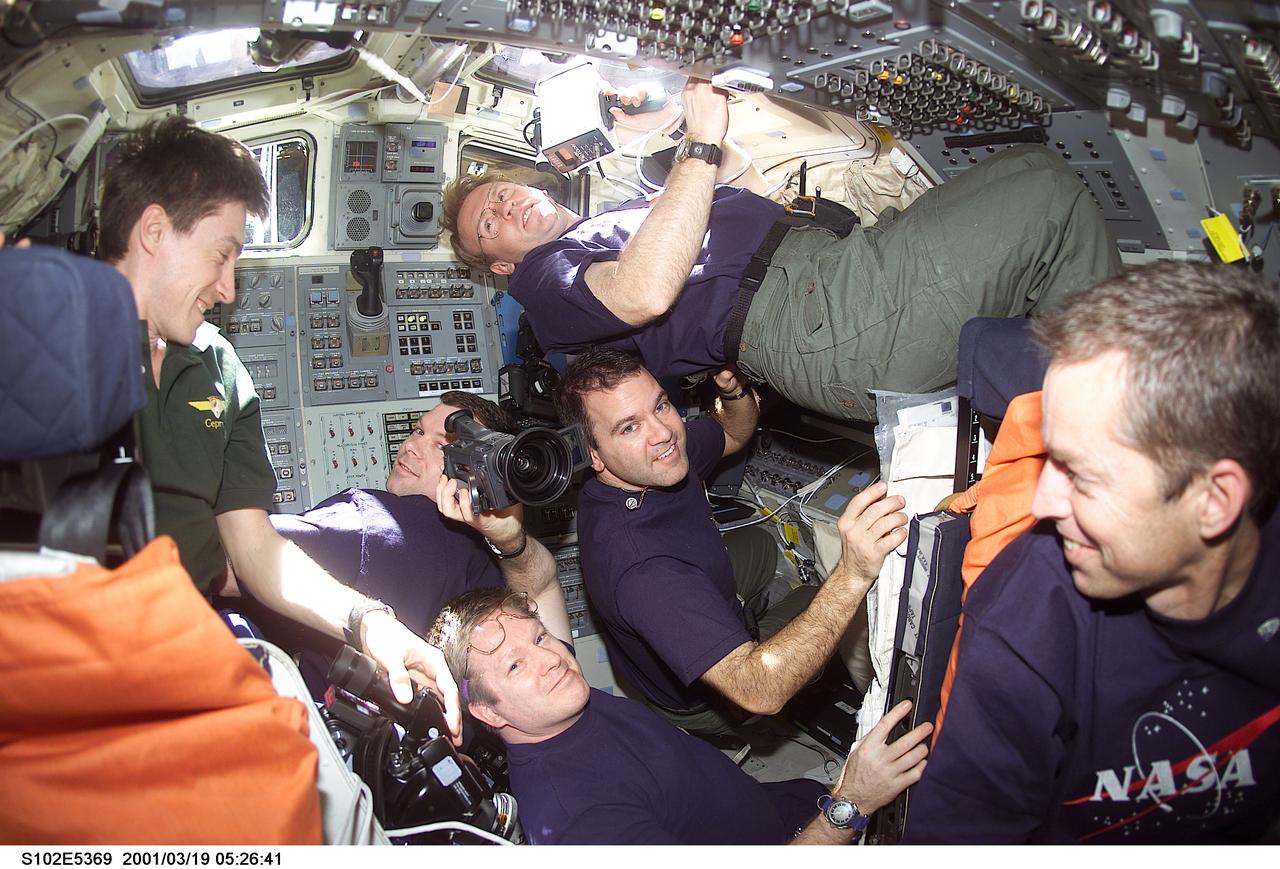 STS102-E-5369 (19 March 2001) --- Five astronauts and a Russian cosmonaut share space on the flight deck of the Space Shuttle Discovery following that spacecraft's separation from the International Space Station (ISS). Cosmonaut Sergei K. Krikalev, far left, joins astronaut William M. (Bill) Shepherd (bottom center) and cosmonaut Yuri P. Gidzenko (out of frame) on the return trip after several months aboard the ISS outpost. The other STS-102 crew members are (beginning second left) astronauts James M. Kelly, pilot; and Andrew S.W. Thomas, and Paul W. Richards, both mission specialists; along with astronaut James D. Wetherbee, commander.