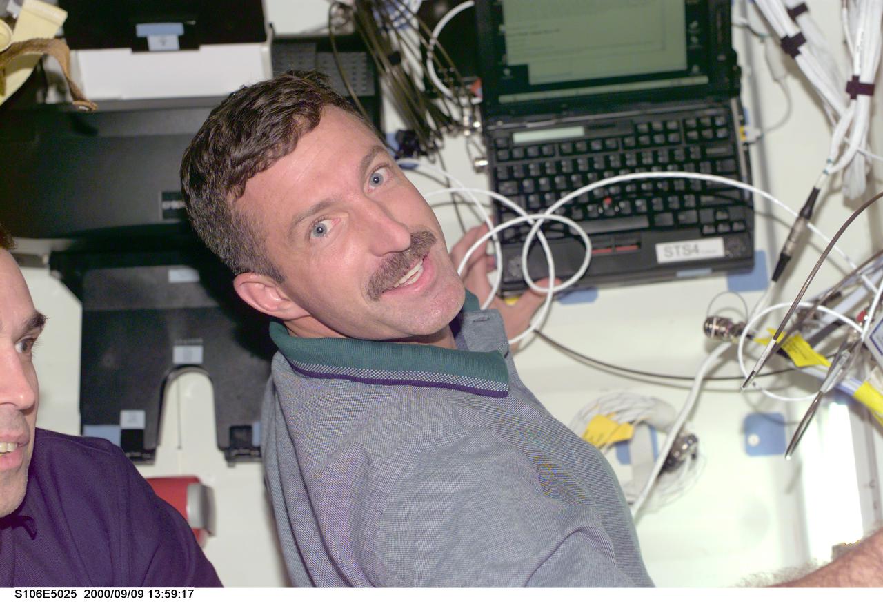 S106-E-5025 (9 September 2000) --- Astronaut Daniel C. Burbank, mission specialist, uses a laptop computer to   keep up with busy chores onboard the   Space Shuttle Atlantis, as the seven-member crew continues its preparation for the upcoming docking with the International Space Station (ISS).