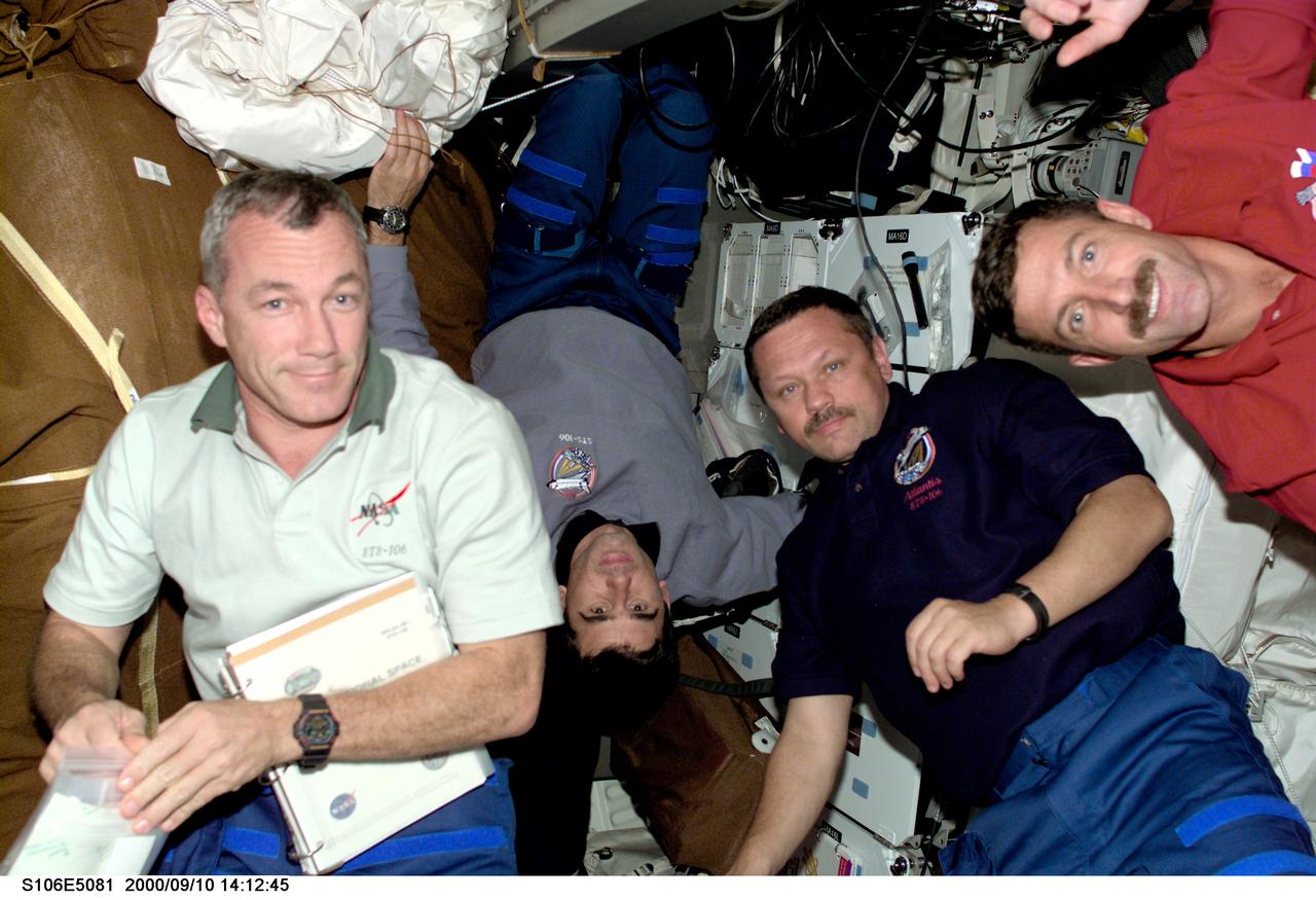 S106-E-5081 (10 September 2000) --- Two cosmonauts and two astronauts discuss supplies to be moved from Atlantis mid deck during Flight Day 3 activity. From the left are astronaut Terrence W. Wilcutt, mission commander; cosmonauts  Yuri I. Malenchenko and Boris V. Morukov, mission specialists representing the Russian Aviation and Space Agency; along with astronaut Daniel C. Burbank, mission specialist.