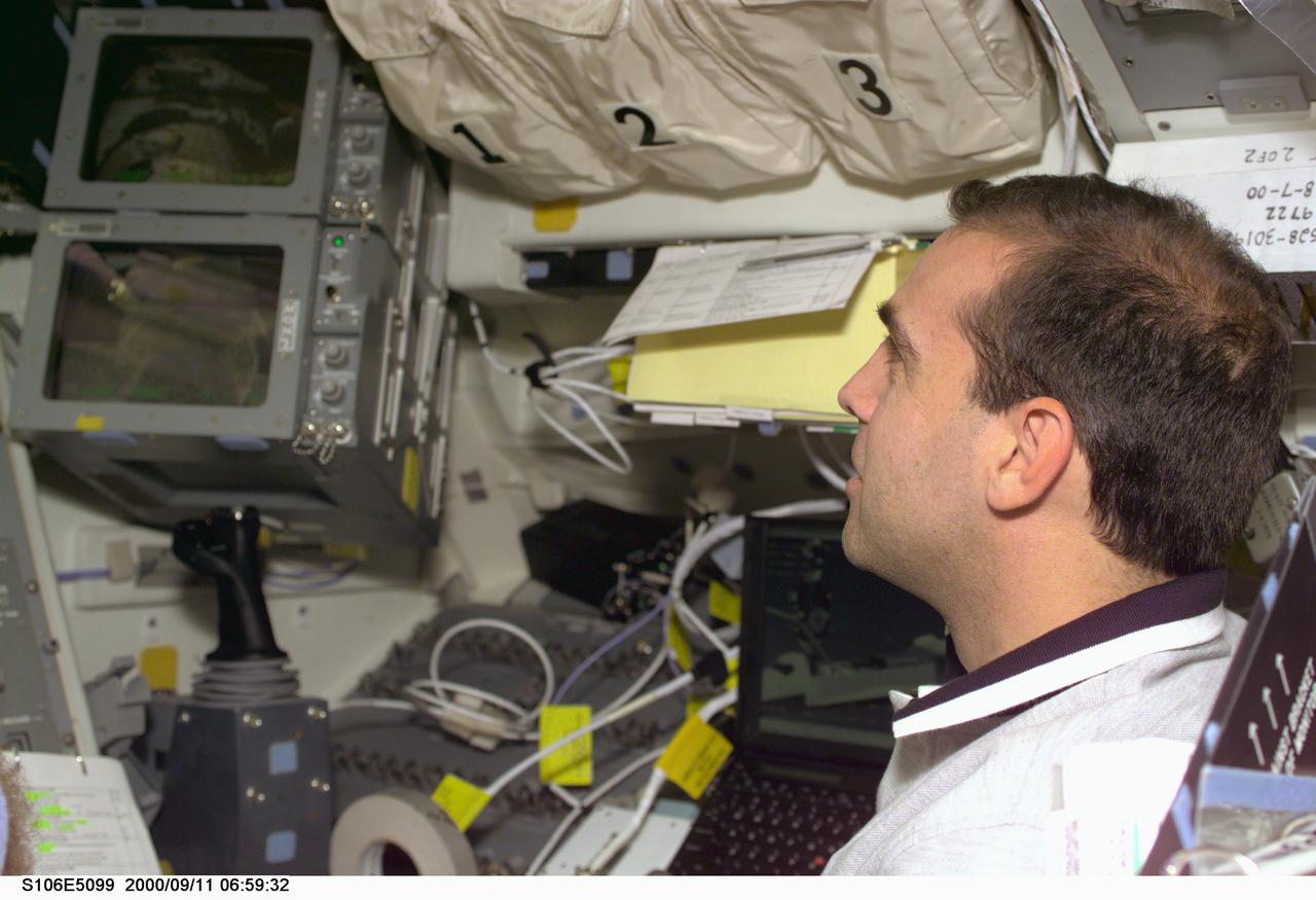STS106-E-5099 (11 September 2000) --- Astronaut Richard A. Mastracchio, mission specialist, stands near viewing windows, video monitors and the controls for the remote manipulator system (RMS) arm (out of frame at left) on the flight deck of the Earth-orbiting Space Shuttle Atlantis during Flight Day 3 activity. Atlantis was docked with the International Space Station (ISS) when this photo was recorded with an electronic still camera (ESC).