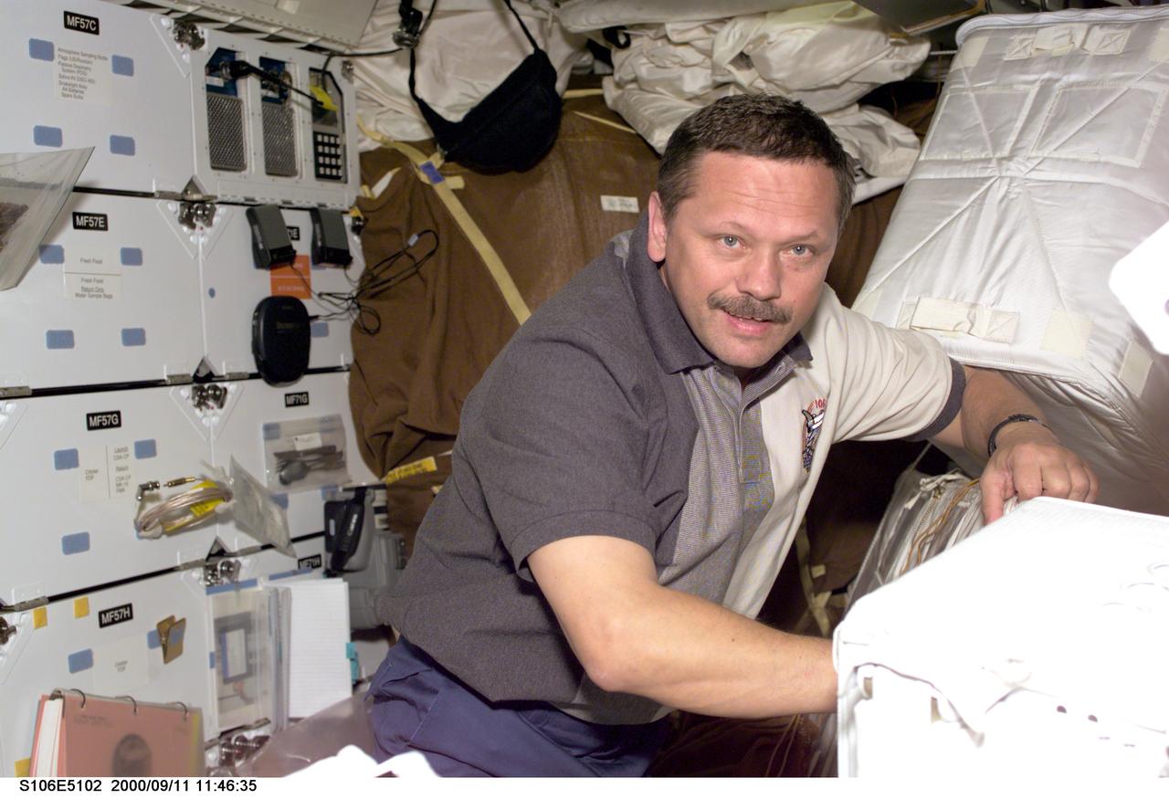 S106-E-5102 (11 September 2000) --- Cosmonaut Boris V. Morukov, mission specialist representing the Russian Aviation and Space Agency, moves around supplies on the mid deck of the Space Shuttle Atlantis.  The seven-member STS-106 crew is involved in preparations for the opening of doors into the International Space Station (ISS) and the movement of supplies into it.