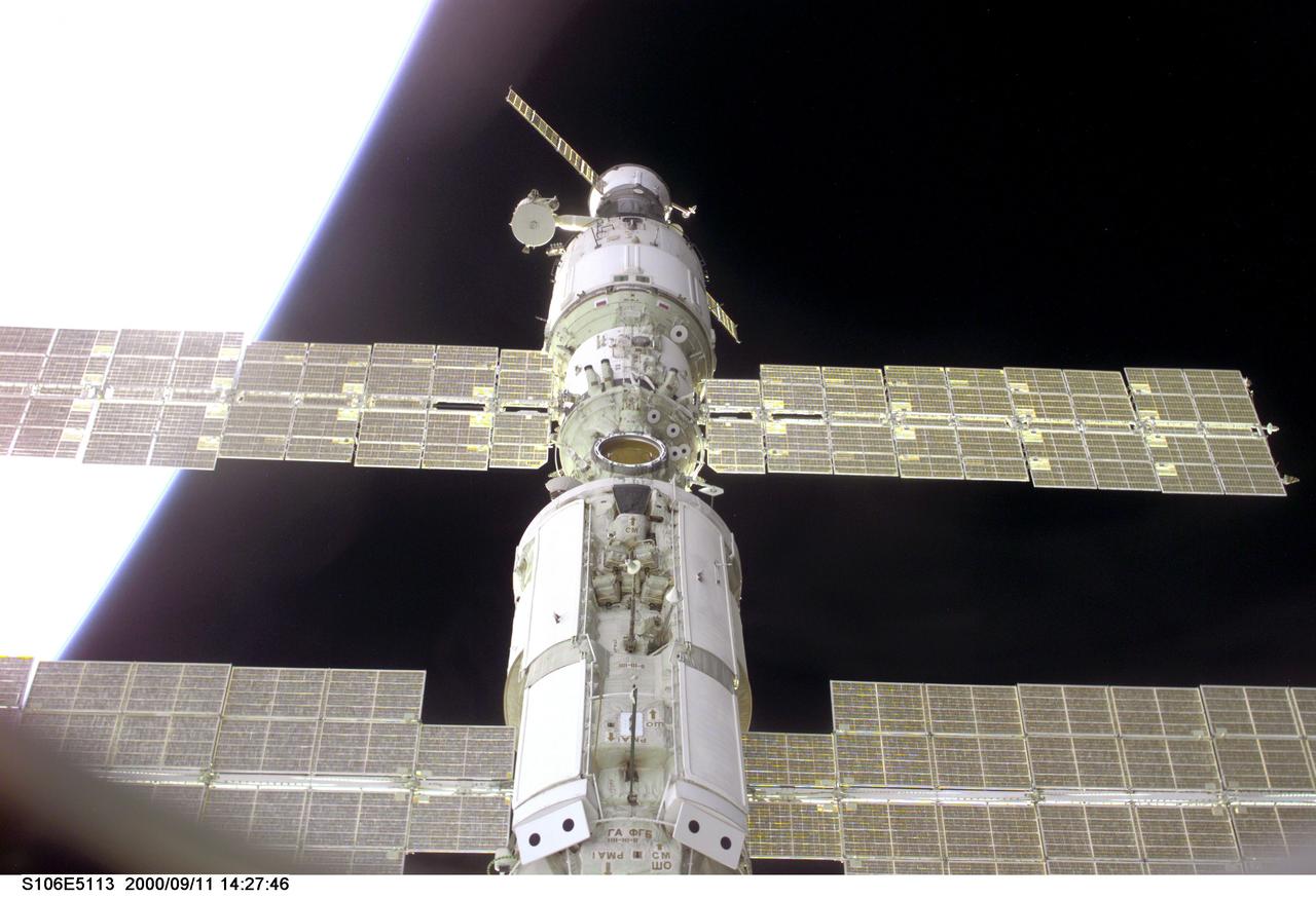 S106-E-5113 (11 September 2000) --- This view of the International Space Station (ISS) was taken while it was docked with the Space Shuttle Atlantis and shows parts of all but one of the current components. From the top are the Progress supply vehicle, the Zvezda service module, and the Zarya functional cargo block (FGB). The Unity, now linked to the docking system of the Atlantis in the cargo bay, is out of view at bottom. A thin blue line represents Earth's atmosphere at left.