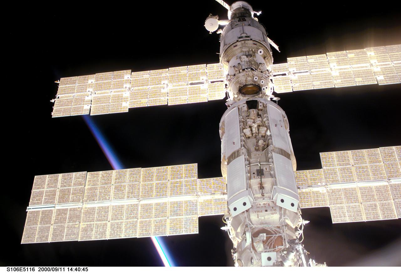 S106-E-5116 (11 September 2000) --- This view of the International Space Station (ISS) was taken while it was docked with the Space Shuttle Atlantis and shows parts of all but one of the current components. From the top are the Progress supply vehicle, the Zvezda service module, and the Zarya functional cargo block (FGB). The Unity, now linked to the docking system of the Atlantis in the cargo bay, is out of view at bottom. A multicolored layer signals a sunset or sunrise on Earth at bottom left.