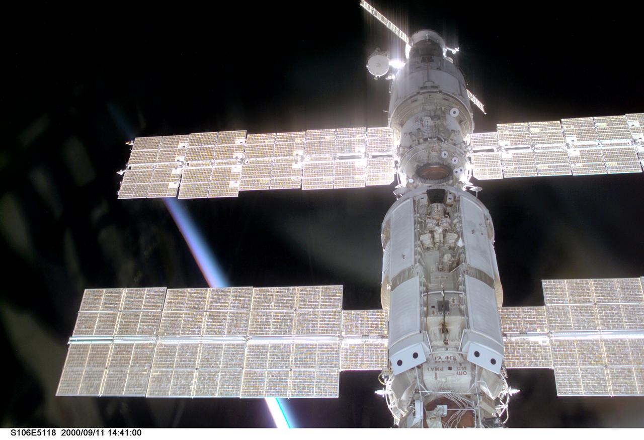 S106-E-5116 (11 September 2000) --- This view of the International Space Station (ISS) was taken while it was docked with the Space Shuttle Atlantis and shows parts of all but one of the current components. From the top are the Progress supply vehicle, the Zvezda service module, and the Zarya functional cargo block (FGB). The Unity, now linked to the docking system of the Atlantis in the cargo bay, is out of view at bottom. A multicolored layer signals a sunset or sunrise on Earth at bottom left.