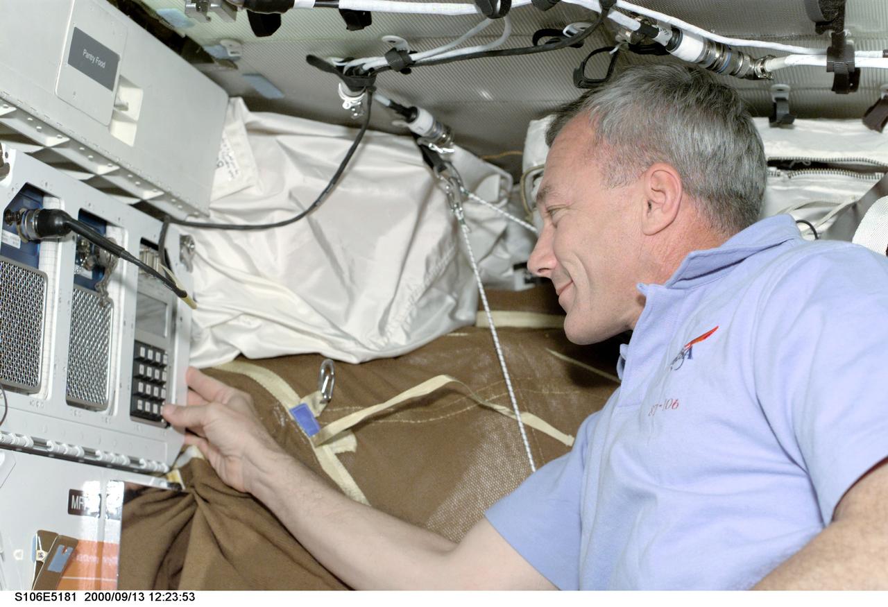 S106-E-5181 (13 September 2000) ---   Astronaut Terrence W. Wilcutt, mission commander, works on the mid deck of the Earth-orbiting Space Shuttle Atlantis.   The commander was likely doing a daily status check on the Commercial Generic Bioprocessing Apparatus (CGBA).