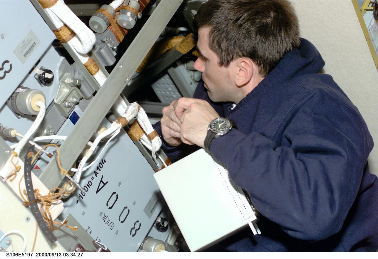 S106-E-5197 (13 September 2000) --- Cosmonaut Yuri I. Malenchenko, mission specialist representing the Russian Aviation and Space Agency, works aboard the Zvezda service module on the International Space Station (ISS).  Electrical work was the hallmark of the day as four of the mission specialists aboard ISS (temporarily docked with the Space Shuttle Atlantis) replaced batteries inside the Zarya and Zvezda modules while supply transfer continued around them.