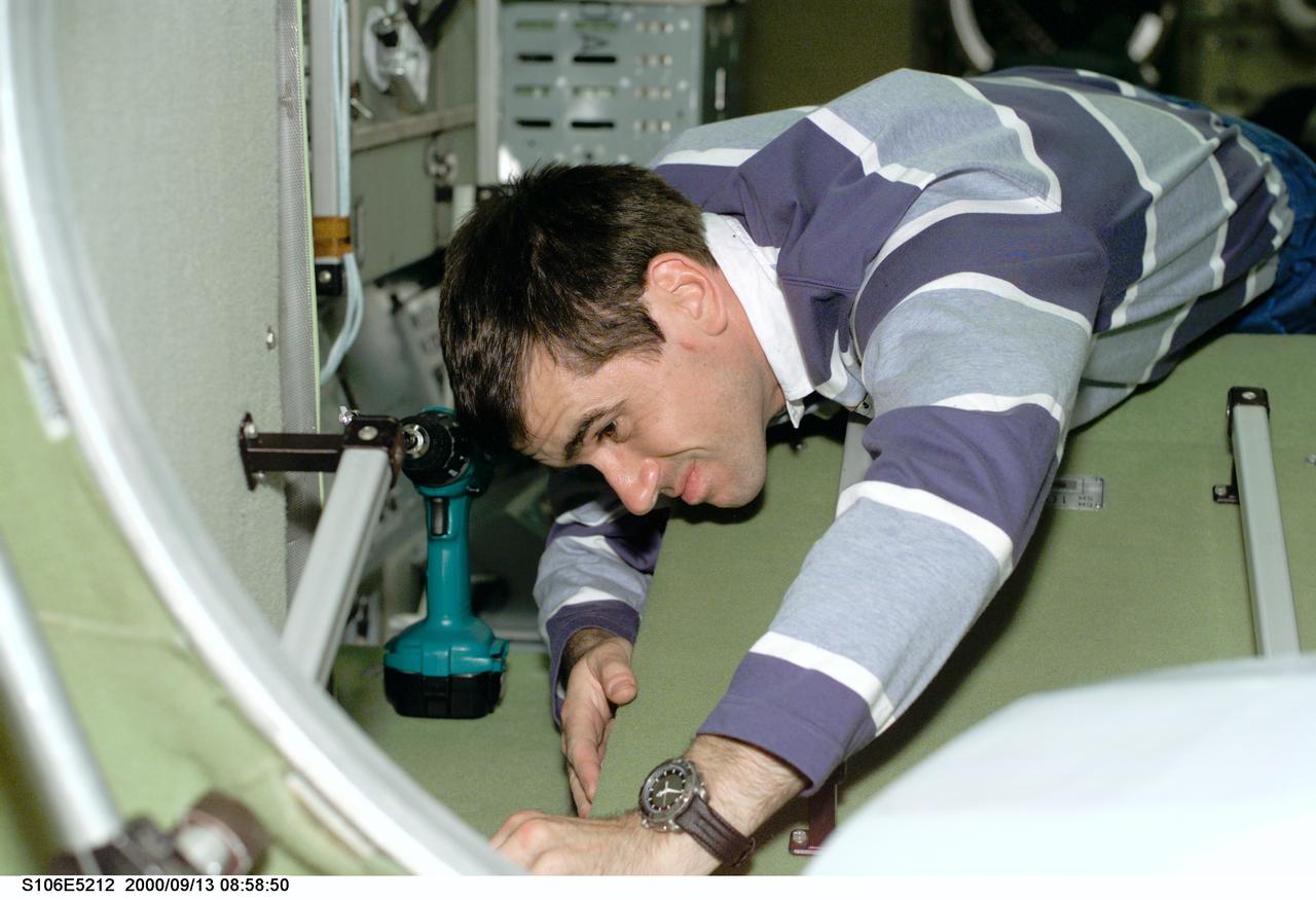 S106-E-5212 (13 September 2000) ---  Cosmonaut Yuri I. Malenchenko checks on new work near a hatchway on the International Space Station (ISS).  Malenchenko is one of two mission specialists representing the Russian Aviation and Space Agency on the STS-106 mission.
