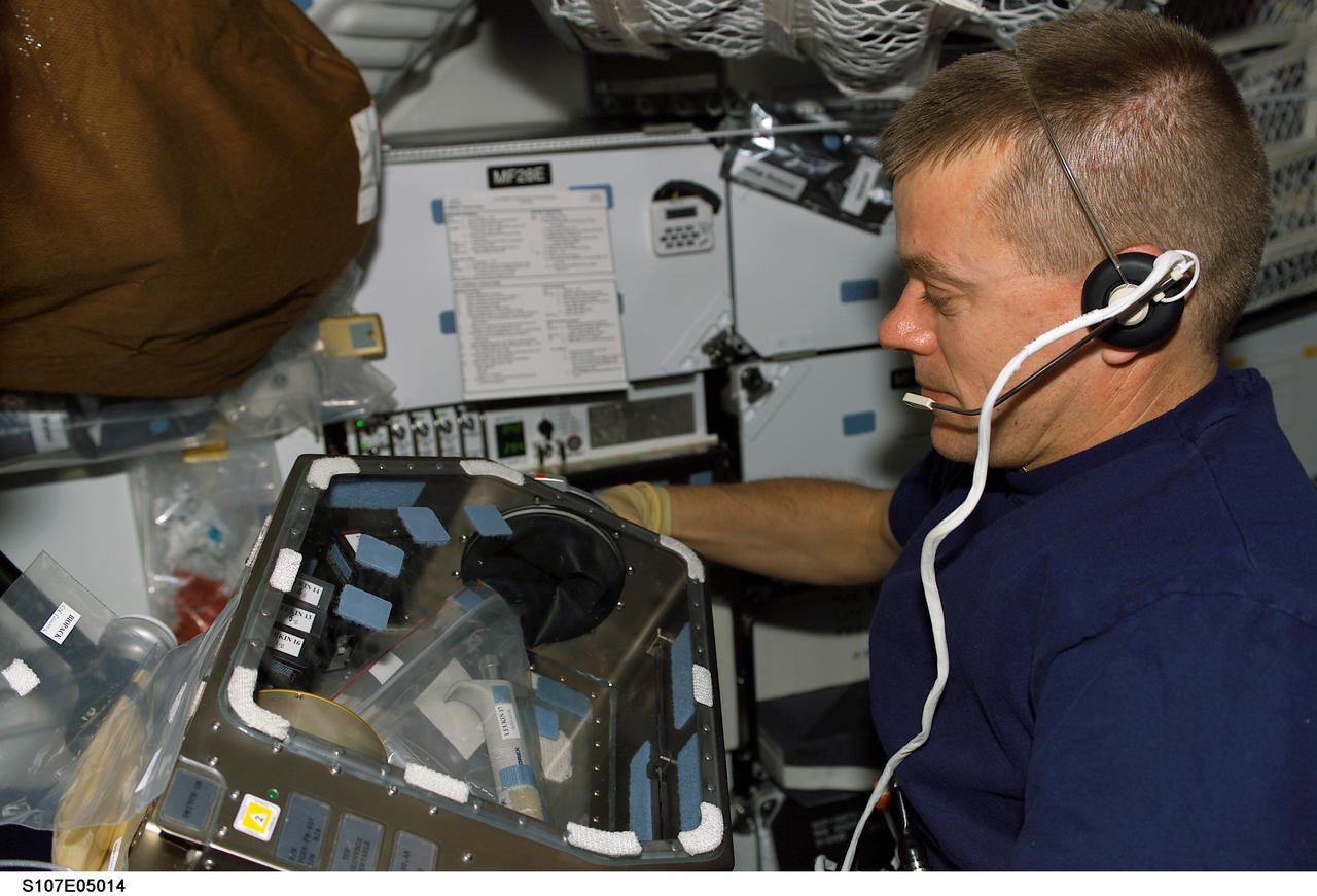 STS107-E-05014 (17 January 2003) --- Astronaut William C. McCool, STS-107 pilot, works with supportive gear for experiments on the SPACEHAB Research Double Module aboard the Space Shuttle Columbia.