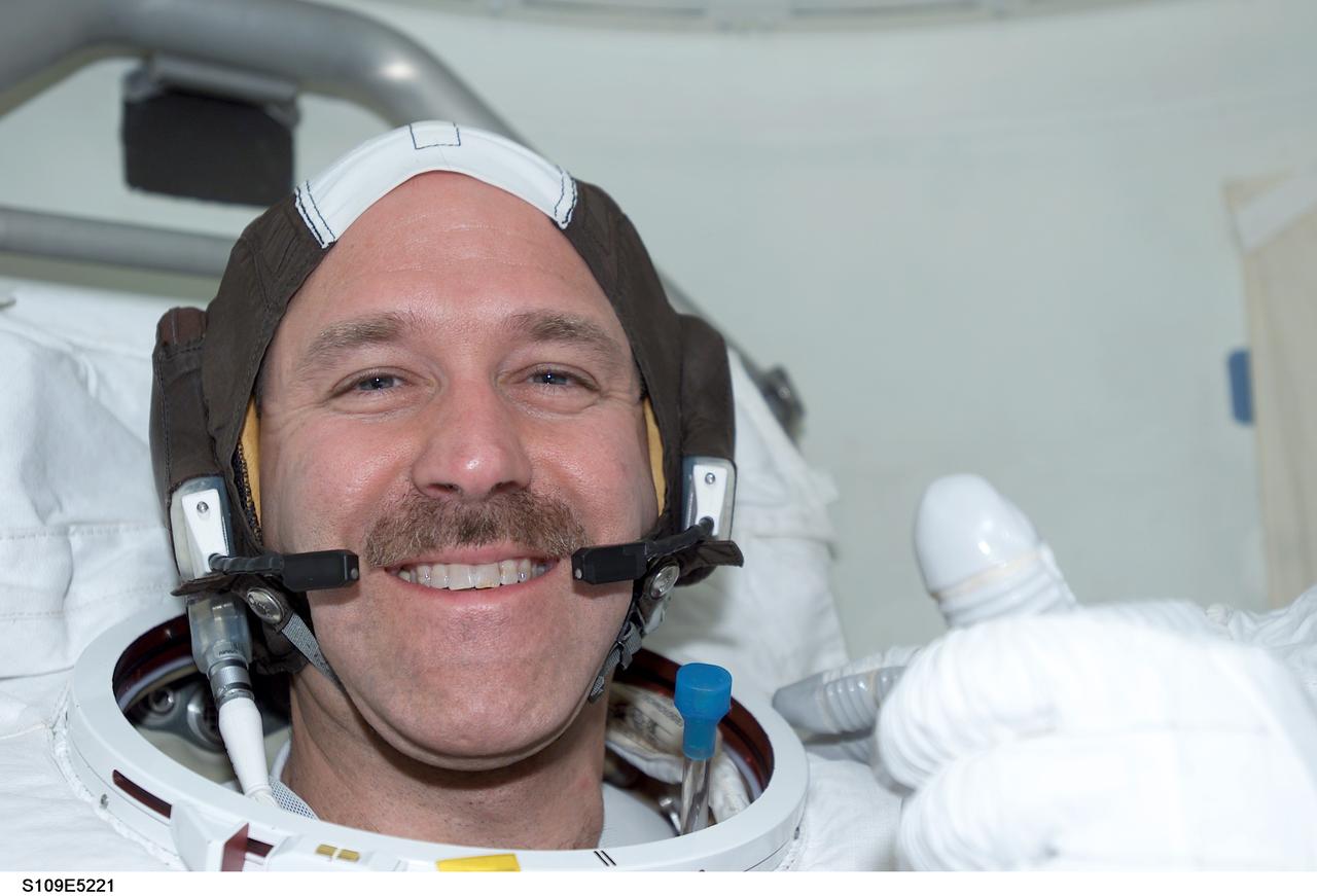 STS109-E-5221 (4 March 2002) ---        Astronaut John M. Grunsfeld, payload commander, signals readiness for the first the first of his assigned STS-109 space walks to perform work  on the Hubble Space Telescope (HST). Astronauts Grunsfeld and Richard M.  Linnehan later donned their helmets and the remainder pieces of their extravehicular mobility unit (EMU) space suits and egressed the Space Shuttle Columbia, eventually replacing  the giant telescope&#0146;s starboard solar  array during a space walk that ended at 7:38 a.m. (CST) or 13:38 GMT March 4, 2002.