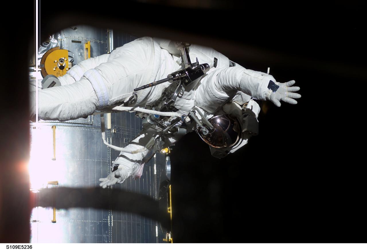 STS109-E-5236 (4 March 2002) --- Astronauts Richard M. (Rick) Linnehan, mission specialist, waves to crewmates inside the Space Shuttle Columbia's crew cabin as he participates in one of his assigned STS-109 space walks to perform work on the Hubble Space Telescope (HST). Astronauts Linnehan and John M. Grunsfeld, payload commander, went on to replace the giant telescope’s starboard solar array. Their seven-hour space walk ended at 7:38 a.m. (CST) or 13:38 GMT March 4, 2002.