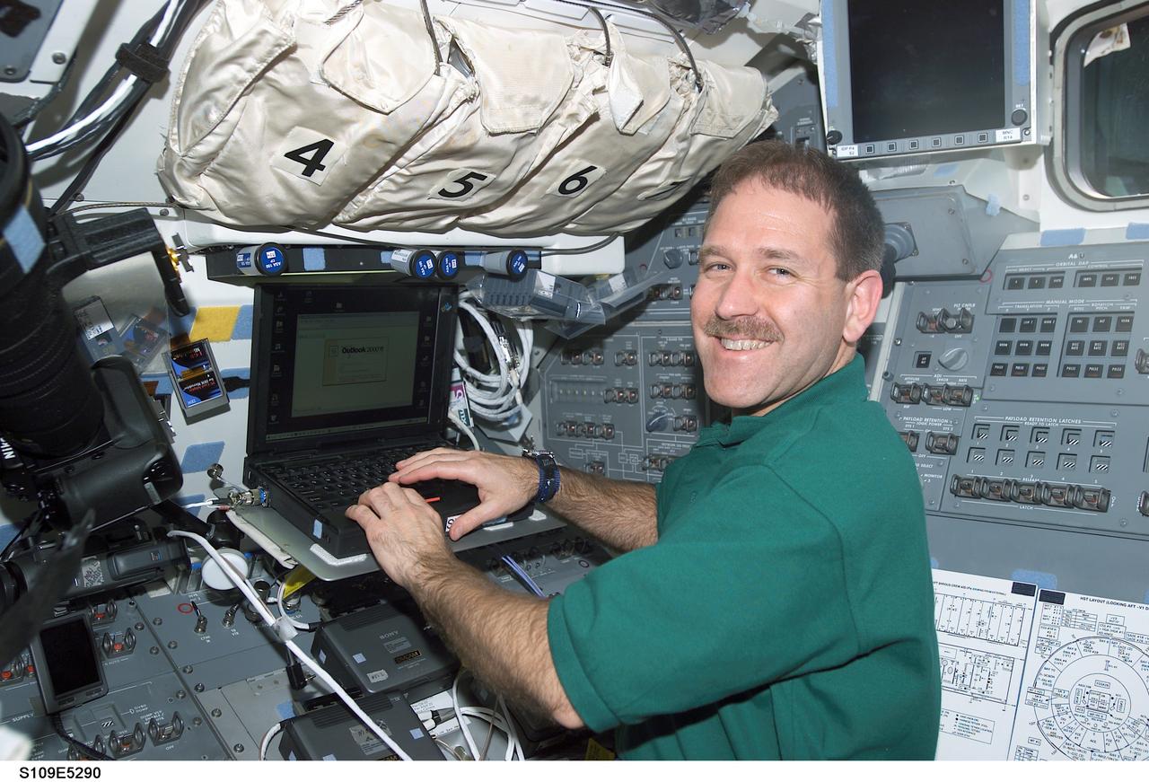 STS109-E-5290 (4 March 2002) --- Astronaut John M. Grunsfeld, payload commander, returns to the shirt-sleeve environment of the Space Shuttle Columbia's aft flight deck. Having  completed a seven-hour space walk, Grunsfeld enters data in a lap top computer. Astronauts Grunsfeld and Richard M. Linnehan successfully replaced the Hubble Space Telescope's  starboard solar array and are scheduled for two more space walks this week. The image was recorded with a digital still camera.