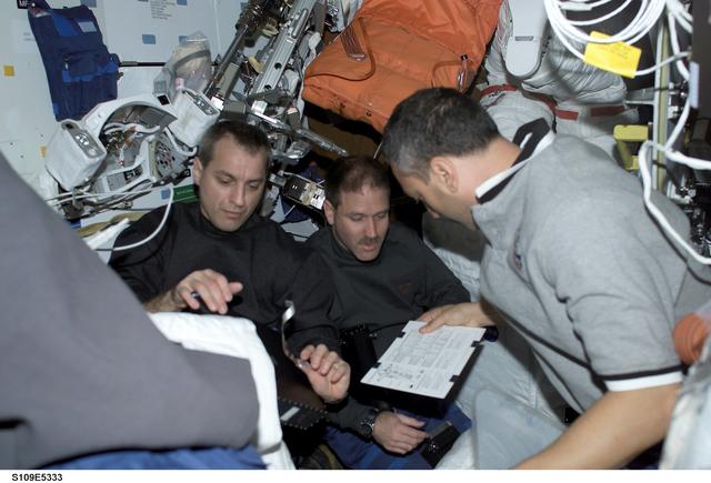 NASA image: STS-109 crewmembers discuss EVA strategy in airlock