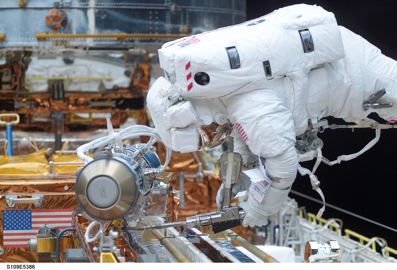 STS109-E-5386 (5 March 2002) --- Astronaut Michael J. Massimino, mission specialist, checks a tool in the cargo bay of the Space Shuttle Columbia during the STS-109 mission's second day of extravehicular activity (EVA). Astronauts Massimino and James H. Newman worked to replace the second set of solar arrays on the Hubble Space Telescope (HST). The image was recorded with a digital still camera.
