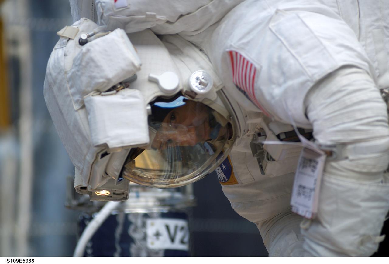 STS109-E-5388 (5 March 2002) --- Astronaut Michael J. Massimino, mission specialist, checks a tool in the cargo bay of the Space Shuttle Columbia during the STS-109 mission's second day of extravehicular activity (EVA). Astronauts Massimino and James H. Newman worked to replace the second set of solar arrays on the Hubble Space Telescope (HST). The image was recorded with a digital still camera.