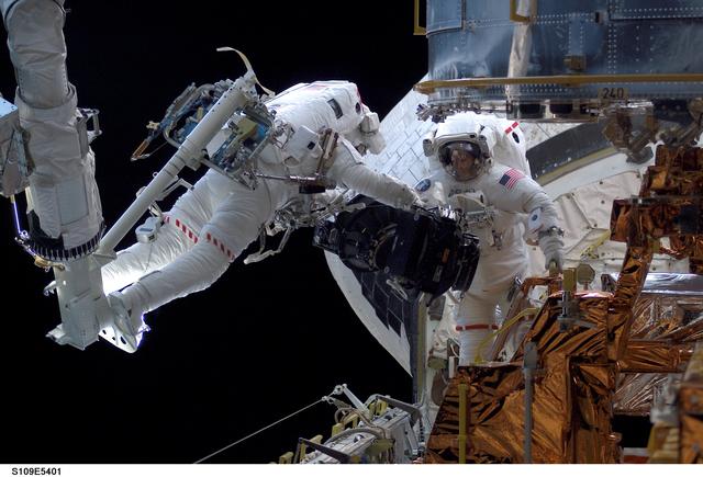 STS-109 MS Massimino and Newman replace Reaction Wheel assembly during EVA 2