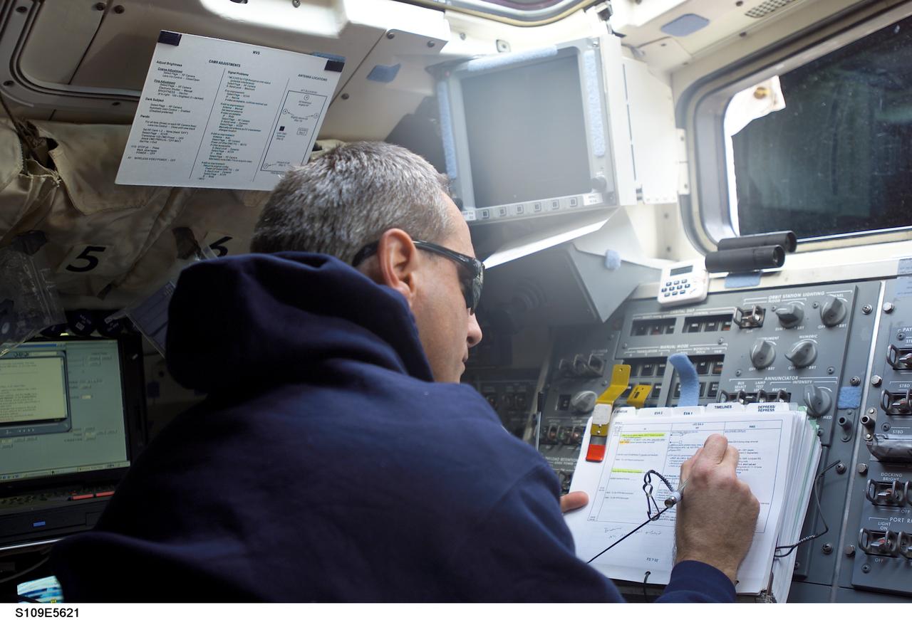 STS109-E-5621 (5 March 2002) --- Astronaut Richard M. Linnehan, mission specialist, monitors the STS-109 mission's second space walk  from the aft flight deck of the Space Shuttle Columbia.  Astronauts James H. Newman and Michael J. Massimino were working on the Hubble Space Telescope (HST), temporarily captured in the shuttle's cargo bay.  Linnehan had participated in the mission's first space walk on the previous day.  This image was recorded with a digital still camera.