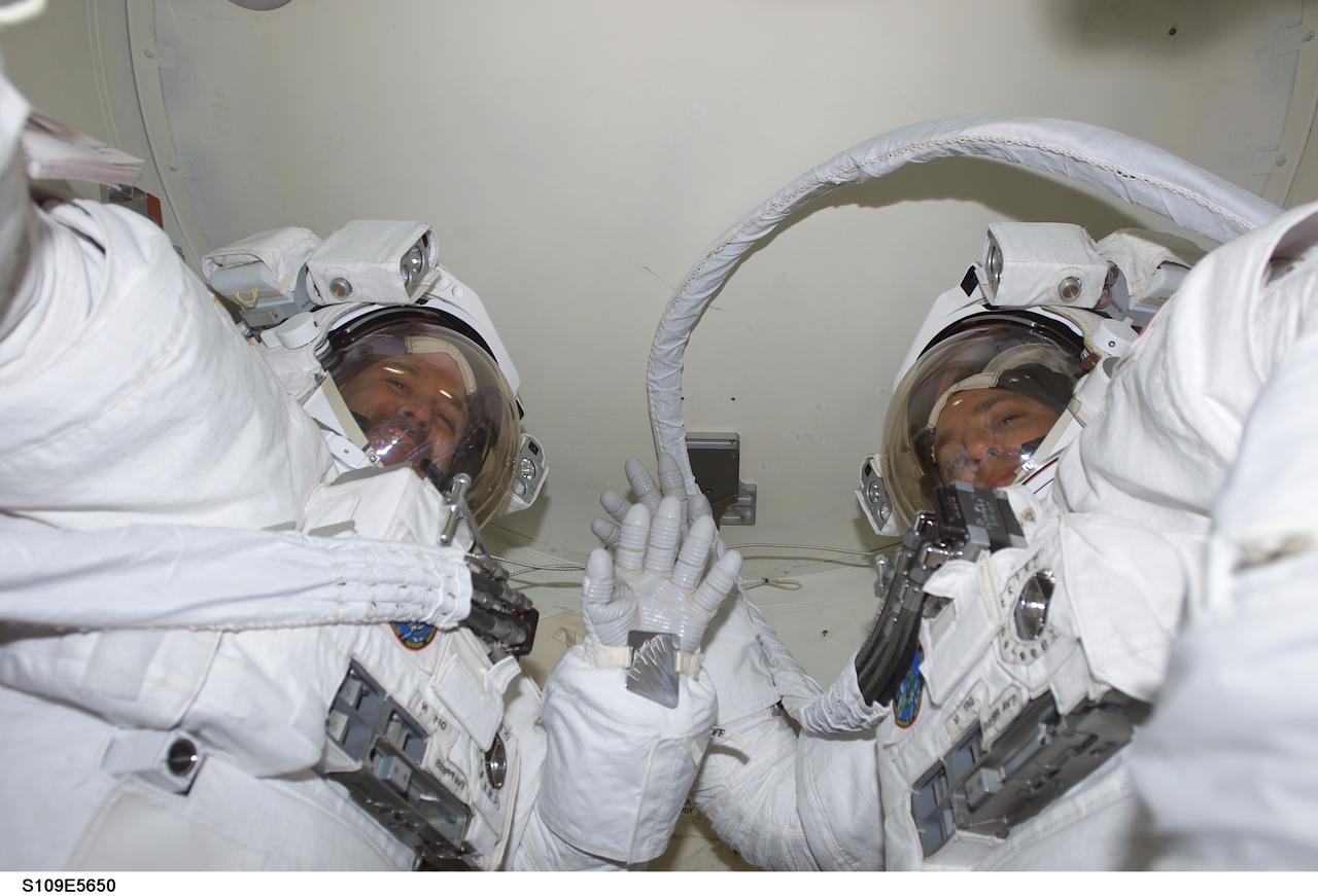 STS109-E-5650 (6 March 2002) --- All suited up and ready for the middle of five scheduled space walks to perform work on the Hubble Space Telescope (HST) are astronauts John M. Grunsfeld (left), payload commander, and Richard M. Linnehan. The two mission specialists shared an extravehicular activity (EVA) just two days ago, successfully replacing the starboard solar array on the Hubble. This image was recorded with a digital still camera.