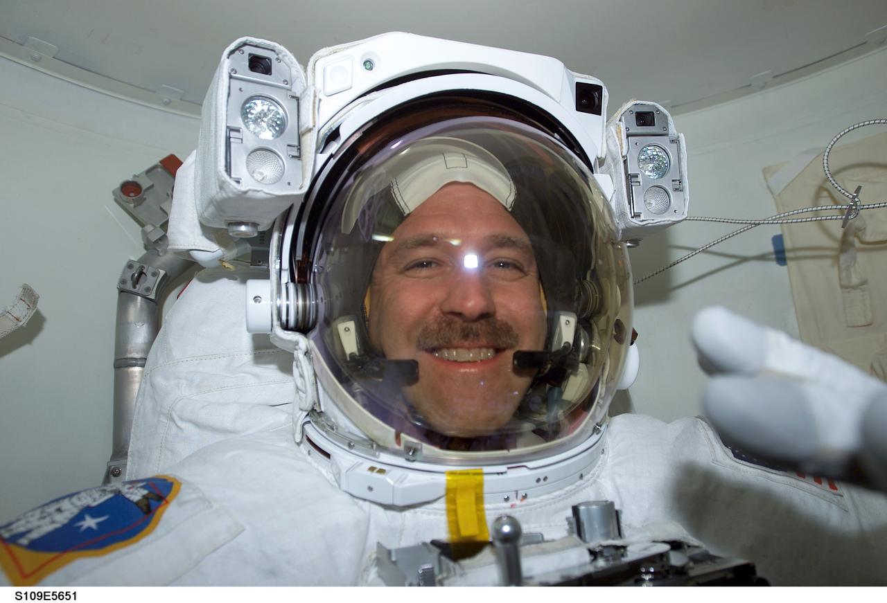 STS109-E-5651 (6 March 2002) --- Astronaut John M. Grunsfeld, payload commander, has donned his extravehicular mobility unit (EMU) space suit and appears ready to begin the middle of five scheduled STS-109 space walks to perform work on the Hubble Space Telescope (HST). Astronauts Grunsfeld and Richard M. Linnehan are scheduled for three shared days of extravehicular activity (EVA). The two mission specialists shared an extravehicular activity (EVA) just two days ago, successfully replacing the starboard solar array on the Hubble. This image was recorded with a digital still camera.