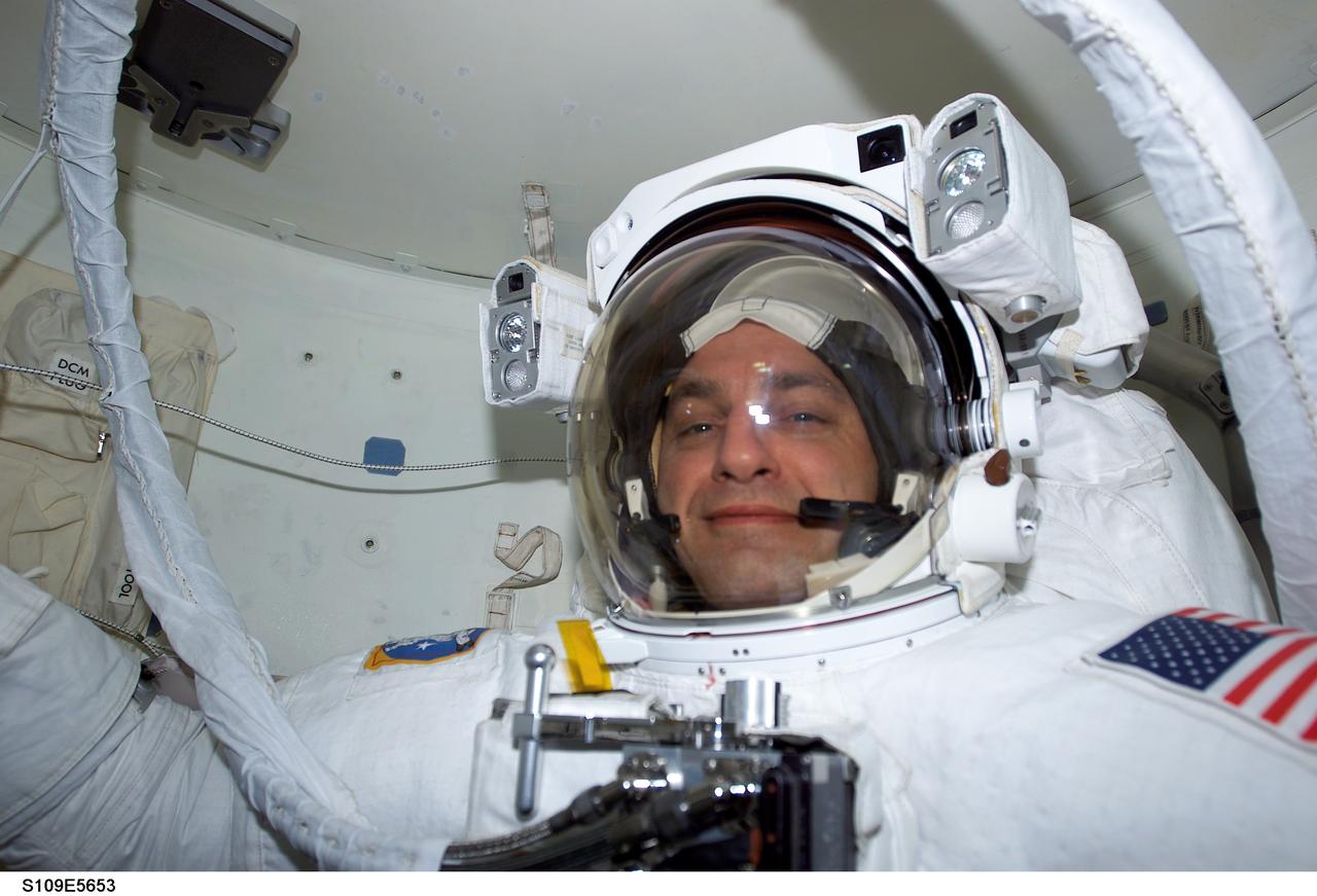 STS109-E-5653 (6 March 2002) --- Astronaut Richard M. Linnehan, mission specialist, has just completed donning his extravehicular mobility unit (EMU) space suit for the second bonafide time during the STS-109 mission. Astronauts Linnehan and John M. Grunsfeld were about to embark on the third of five scheduled STS-109 space walks. The image was recorded with a digital still camera.