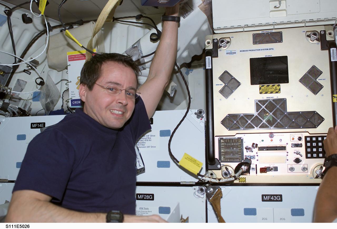 STS111-E-5026 (7 June 2002) --- Astronaut Daniel W. Bursch, who has been aboard the International Space Station (ISS) for the past six months, wastes little time in going to work on board the Space Shuttle Endeavour following linkup of the shuttle and station on June 7, 2002. Bursch, who will return home aboard Endeavour in a few days, is pictured at the Biomass Production System (BPS) on Endeavour's mid deck.