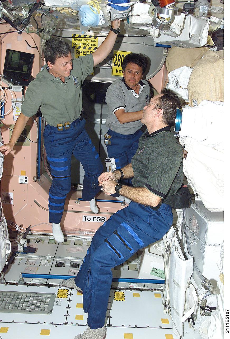 STS111-E-5107 (7 June 2002) --- Astronauts Peggy A. Whitson (left), Expedition Five flight engineer, Franklin R. Chang-Diaz, STS-111 mission specialist, and Carl E. Walz, Expedition Four flight engineer, are photographed in the Unity node on the International Space Station (ISS).