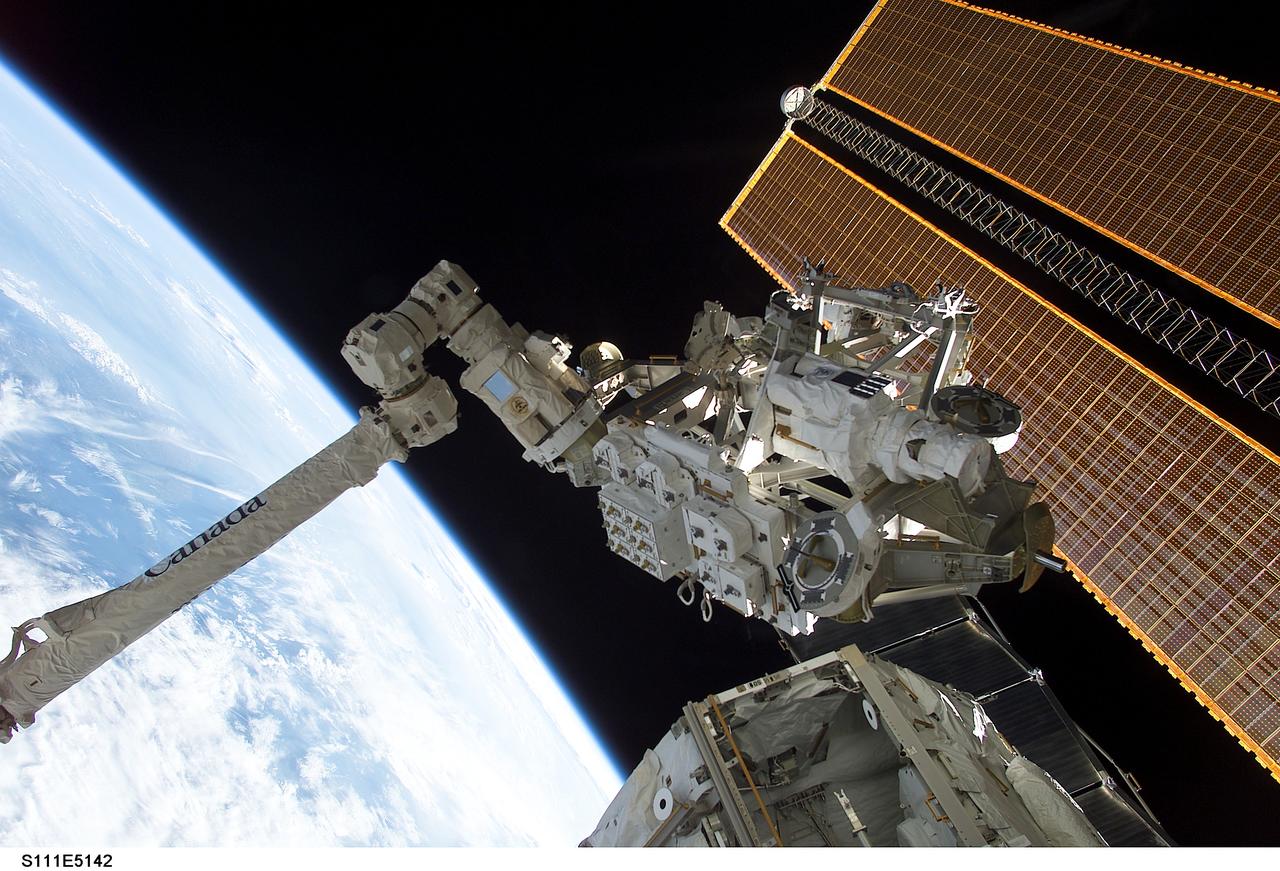 STS111-E-5142 (10 June 2002) --- Backdropped by the blackness of space and Earth’s horizon, the Mobile Remote Servicer Base System (MBS) is moved by the Canadarm2 for installation on the International Space Station (ISS). Astronauts Peggy A. Whitson, Expedition Five flight engineer, and Carl E. Walz, Expedition Four flight engineer, attached the MBS to the Mobile Transporter on the S0 (S-zero) Truss at 8:03 a.m. (CDT) on June 10, 2002. The MBS is an important part of the station’s Mobile Servicing System, which will allow the station’s robotic arm to travel the length of the station to perform construction tasks.