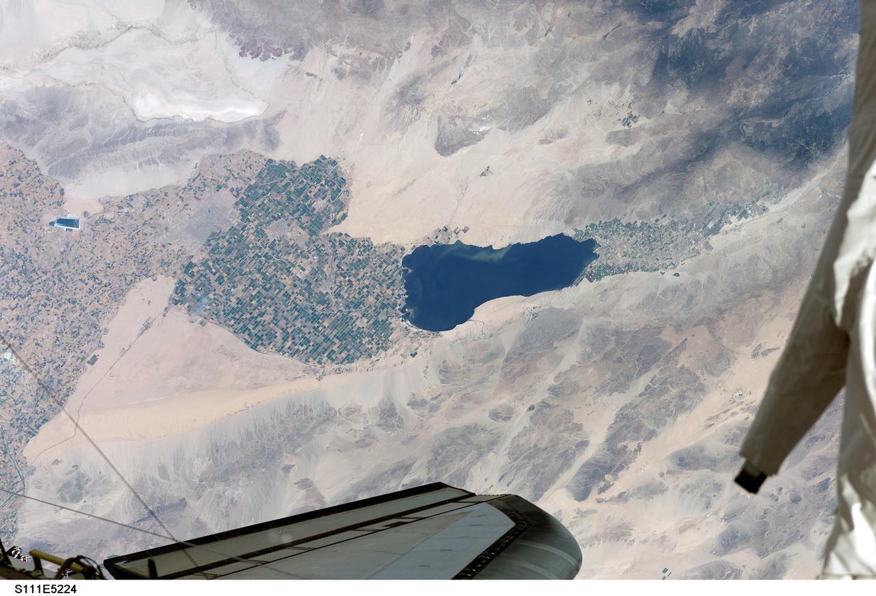 STS111-E-5224 (12 June 2002) --- Southern California&#0146;s Salton Sea is routinely a prominent visual for astronauts passing overhead on the shuttle or International Space Station (ISS).  This large lake, photographed from the station while docked to the Space Shuttle Endeavour by one of the STS-111 crew members, supports the rich agricultural fields of the Imperial, Coachella and Mexicali Valleys in the California and Mexico desert.  According to geologists, the Salton Sea formed by accident in 1905 when an irrigation canal ruptured, allowing the Colorado River to flood the Salton Basin.  Today the Sea performs an important function as the sink for agricultural runoff. Water levels are  maintained by the runoff from the surrounding agricultural valleys.   The Salton Sea salinity is high -- nearly 1/4 saltier than ocean water --but it remains an important stopover point for migratory water birds, including several endangered species.  Scientists also noted that the region  experiences several environmental problems.  The recent increased demands for the limited Colorado River water, the scientists point out,  threatens the amount of water allowed to flow into the Salton Sea, and increased salinity with decreased water levels could trigger several regional environmental crises.  The agricultural flow into the Sea includes nutrients and agricultural by-products, increasing the productivity and likelihood of algae blooms. This image shows either a bloom, or suspended sediment (usually highly organic) in the water that has been stirred up by winds.