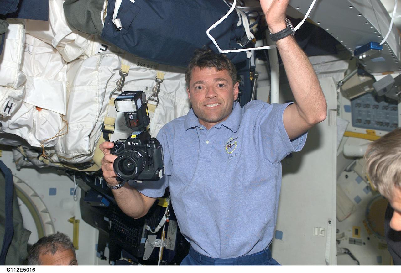 STS112-E-05016 (8 October 2002) --- Astronaut Jeffrey S. Ashby, STS-112 mission commander, holds a still photo camera on the middeck of the Space Shuttle Atlantis.
