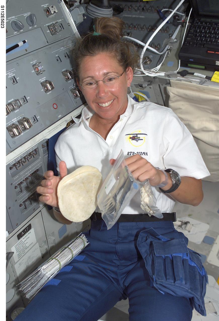STS112-E-05023 (8 October 2002) --- Astronaut Sandra H. Magnus, STS-112 mission specialist, prepares to eat a meal on the aft flight deck of the Space Shuttle Atlantis.