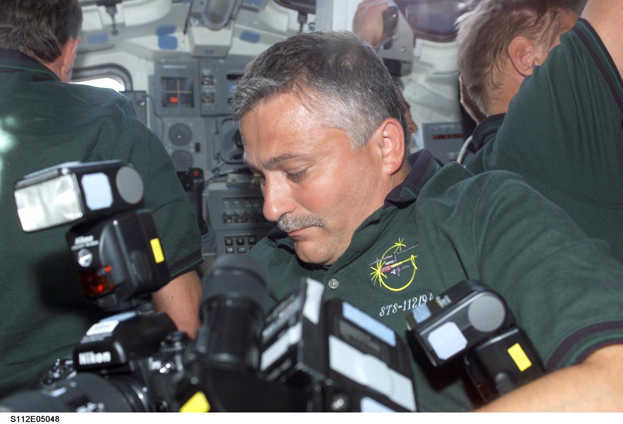 STS112-E-05048 (9 October 2002) --- Cosmonaut Fyodor N. Yurchikhin, STS-112 mission specialist representing Rosaviakosmos, works with camera equipment on the flight deck of the Space Shuttle Atlantis.