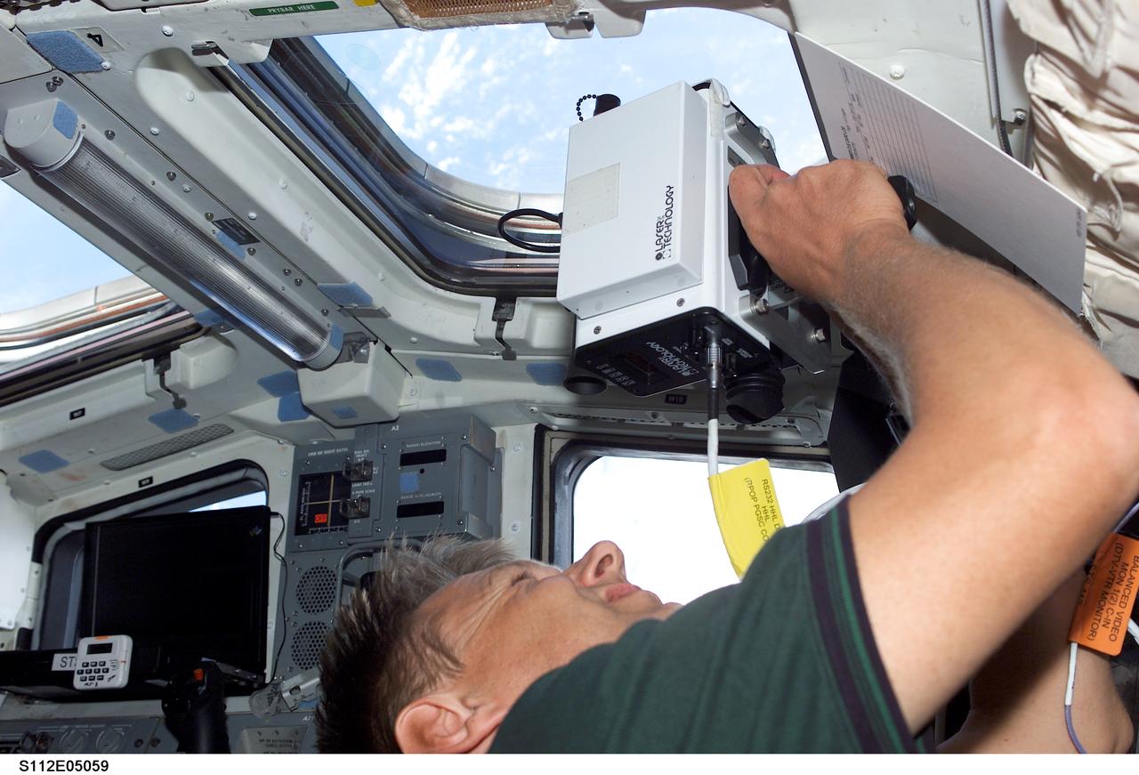 STS112-E-05059 (9 October 2002) --- Astronaut Piers J. Sellers, STS-112 mission specialist, uses a laser ranging device on the aft flight deck of the Space Shuttle Atlantis. This instrument is a regularly called-on tool during rendezvous operations with the International Space Station (ISS).