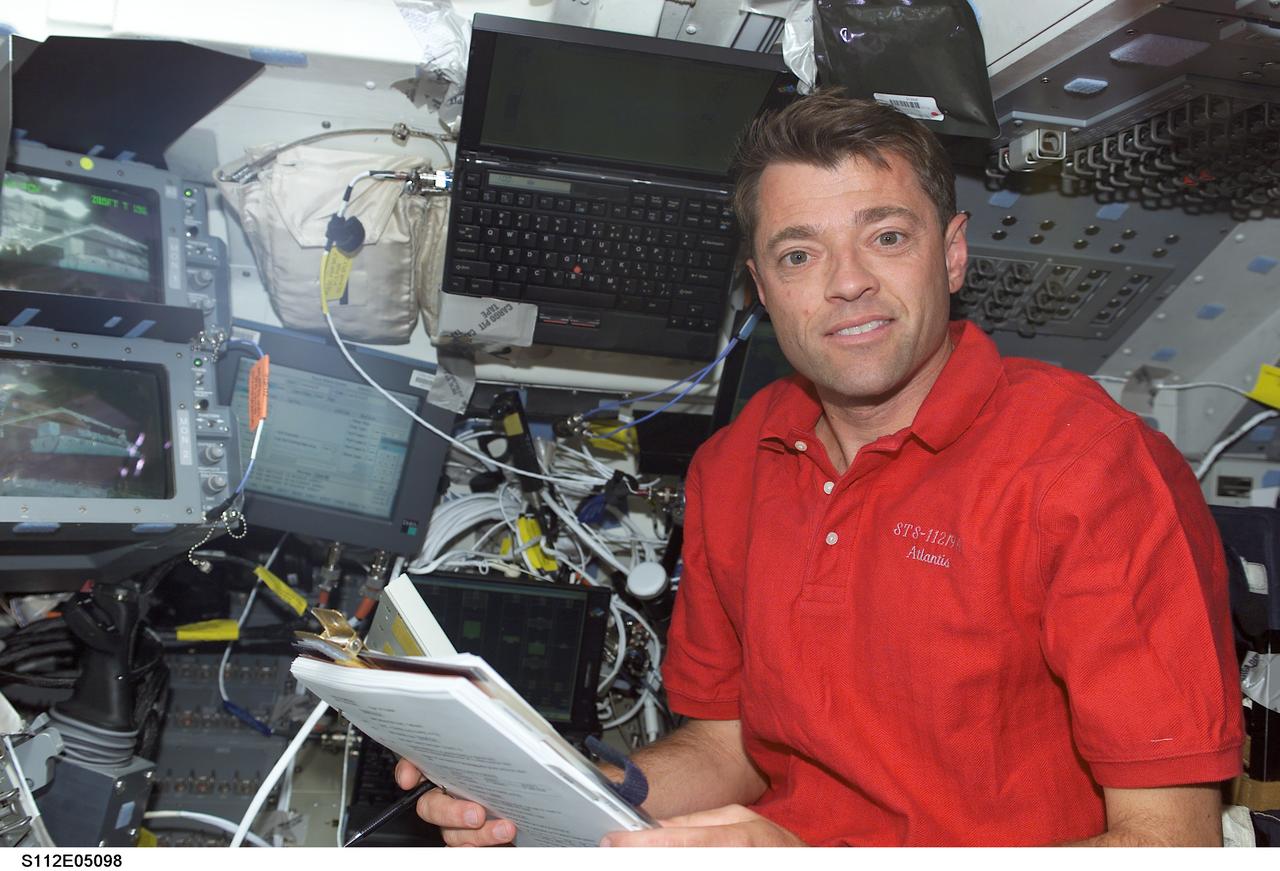 STS112-E-05098 (10 October 2002) --- Astronaut Jeffrey S. Ashby, STS-112 mission commander, looks over a procedures checklist on the aft flight deck of the Space Shuttle Atlantis.