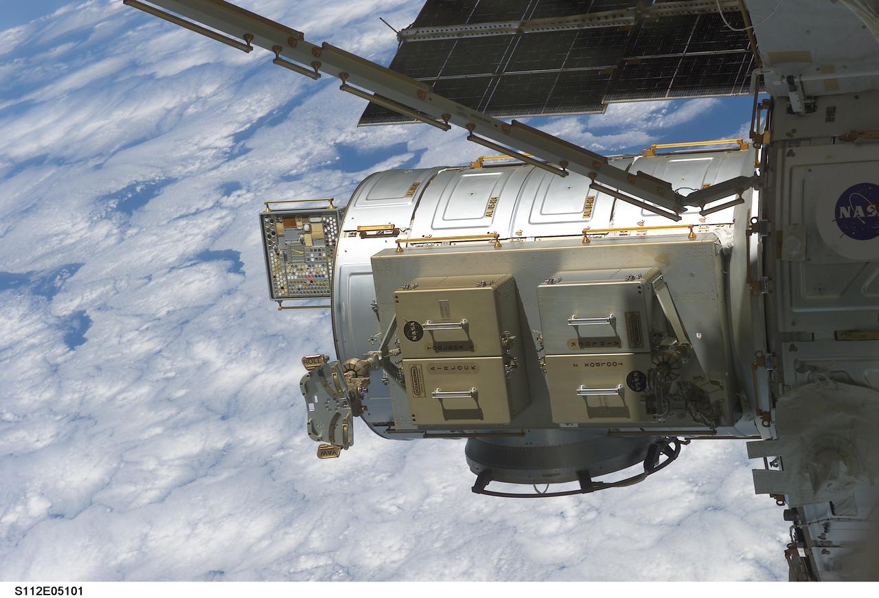 STS112-E-05101 (10 October 2002) --- Backdropped by a blue and white Earth, the Quest Airlock on the International Space Station (ISS) was photographed by a crewmember. Astronauts David A. Wolf and Piers J. Sellers, both STS-112 mission specialists, used the airlock to exit the station for the first scheduled session of extravehicular activity (EVA) which began at 10:21 a.m. on October 10, 2002.